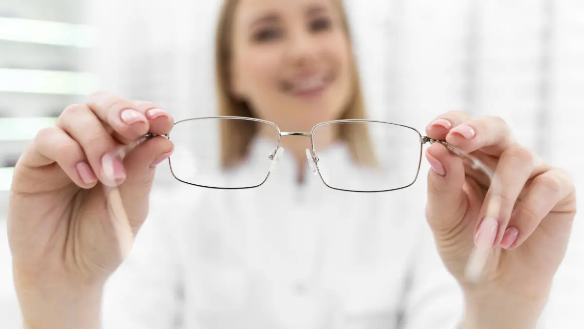 Kobieta prezentująca lekkie metalowe okulary korekcyjne, wybór odpowiednich oprawek i szkieł dopasowanych do indywidualnych potrzeb wzroku